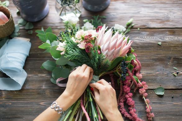 Floristin steckt bindet einen Blumenstrauß